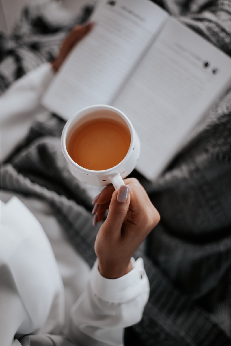 Photo by Farzad Mohamadi person holding white ceramic mug withe tea
